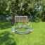 Bicycle merry-go-round dans un cadre de terrain de jeu avec de l'herbe verte et des arbres en arrière-plan.