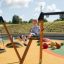 Enfant jouant sur un Bird Nest Single Swing (BNS 120 cm) dans une aire de jeux.