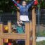Deux enfants jouant dans la maisonnette Fortress II avec toboggan.