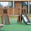 Maisonnette Mini Play II pour enfants avec mur d’escalade en bois et toboggan sur l’aire de jeux.
