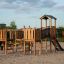 Challenger Modern Nature single slide structure de jeu en bois sur une surface sablonneuse.