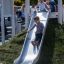 Des enfants jouent sur le Hill Slide h120 dans un parc.