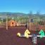 Équipement de jeu Double Pony rocking dans un parc avec des montagnes en arrière-plan.