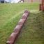 Wooden Stair élément d'escalade pour aire de jeux installé sur une colline herbeuse