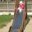 Un enfant descendant le Camel single slide dans une aire de jeux.