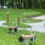 Deux jouets Bike rocking dans un parc avec une zone herbeuse et des arbres en arrière-plan.