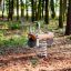 Bascule à ressort pour enfants en forme de vélo dans une aire de jeux en forêt.
