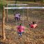 Des enfants jouent sur Nature Double Swing dans un parc en automne.