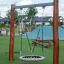 Équipement de jeu extérieur Single Swing avec poteaux en bois et siège en filet.