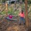 Des enfants jouent sur la balançoire simple dans un parc en automne.
