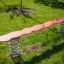 Bascule de jeu rouge Balance avec ressorts en acier dans un parc verdoyant.