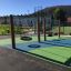 Double swing en bois installé sur une aire de jeux colorée avec sol amortissant.