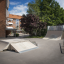 Quarter-Pipe haute et autres rampes de skateboard dans un quartier résidentiel.
