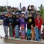 Enfants posant avec des skateboards dans un skatepark.