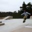 Un jeune skateboarder effectuant un saut dans un skatepark.
