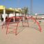 Cross Climber steel structure sur une aire de jeux sablonneuse.