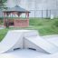 Rampe de skate dans un parc à côté d’un gazebo en bois.