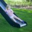 Enfant glissant sur le toboggan de l'aire de jeux Challenger Aztec dans un parc.