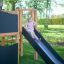 Enfant jouant sur le toboggan de la structure de jeu Little Jungle Nature dans un parc