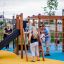 Structure de jeu en bois Climbing Kiosk Nature avec toboggan et filet d’escalade, enfants jouant