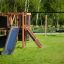 Climbing Kiosk Nature avec toboggan et balançoire dans un parc herbeux