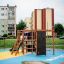 Des enfants jouent sur l’ensemble de jeux Climbing Kiosk Nature dans une zone urbaine.