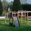 Gorilla Nature aire de jeux en bois avec toboggans et structures d'escalade dans un parc verdoyant.