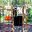 Enfant grimpant sur la structure de jeu en bois Gorilla Nature en extérieur.