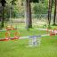 Double Seesaw dans un parc avec de l’herbe verte et des arbres.