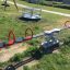 Double Seesaw dans une aire de jeux avec des poignées rouges et des sièges noirs