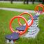 Double Seesaw dans une aire de jeux avec des poignées rouges et une base à ressort.