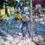 Enfant grimpant sur Powerclimber climbing net dans une aire de jeux.