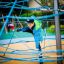 Un enfant grimpe sur Powerclimber climbing net dans l’aire de jeux.