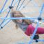 Une fille grimpe sur Powerclimber climbing net dans l’aire de jeux.