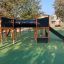 Équipement de aire de jeux Square Play Nature avec un toboggan et une structure d’escalade dans un parc.