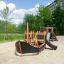 Bateau de jeu en bois Small Ship Nature avec toboggan dans une aire de jeu sablonneuse.