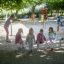 Enfants jouant sur l’équipement de jeu Bridge dans un parc.