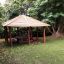 Gazebo de terrain de jeu en bois Firehouse dans un parc verdoyant.