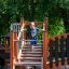 Structure de terrain de jeu en bois Tritowers Nature castle with slide avec enfant montant les escaliers