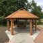 Gazebo en bois Long Firehouse avec bancs dans un parc.