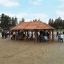 Gazebo en bois nommé Long Firehouse dans un parc, entouré de personnes