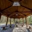 Pavillon extérieur en bois Long Firehouse avec bancs dans un cadre forestier