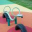 Équipement de aire de jeux SeeSaw avec base en pneus sur une surface en caoutchouc colorée.