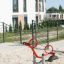 Équipement de aire de jeux moderne rouge SeeSaw dans une aire de jeu sablonneuse.