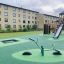 SeeSaw dans une aire de jeux moderne avec toboggans et structures d'escalade.