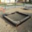 Aire de jeux Sandbox Nature avec bordures en bois et sable à l'intérieur.