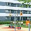 Baby Double Swing sur une aire de jeux colorée dans un quartier résidentiel.
