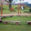 Firepit seating bancs en bois disposés en cercle sur l’herbe de l’aire de jeux