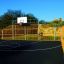 Terrain de sport extérieur avec panier de basket et clôtures jaunes Santiago Bernabeu.
