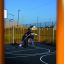Enfants jouant au basket sur l’aire de jeux Santiago Bernabeu avec des équipements colorés en arrière-plan.
